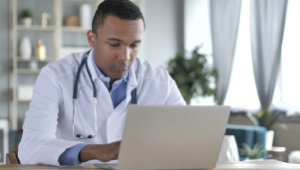 African-American Doctor Working On Laptop